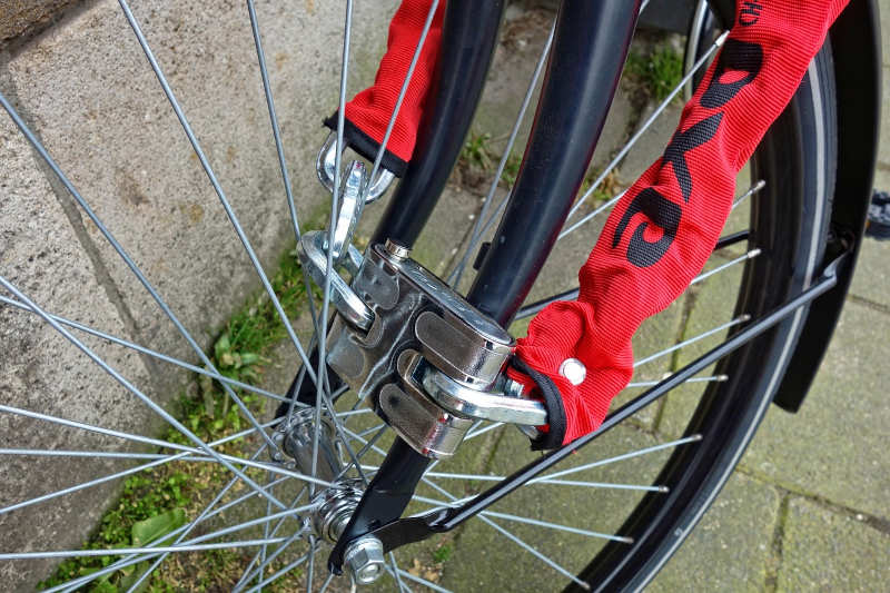 Image of a sturdy bicycle chain and lock around a bike wheel